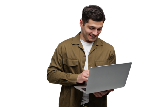 Smiling young man engages with laptop while standing against a simple white backdrop in a bright, transparent background