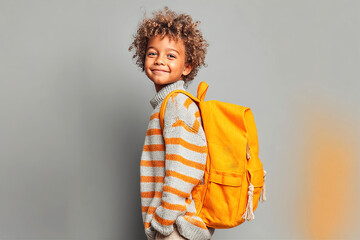 Happy Child with Backpack Ready for Back to School – Joyful Education Moment. Studio portrait of  7 years old boy