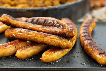 fresh juicy toasted German sausages lie on the grill, ready to eat.