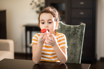 Cute little girl monitoring peak expiratory with peak flow meter at home. Hand medical device used...
