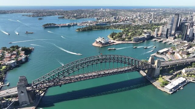 Drone aerial over Sydney Harbour looking down on Harbour Bridge boats and distant ocean horizon