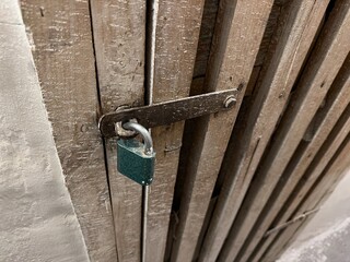 Closed old lock on wooden door in house basement