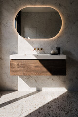 A walnut floating vanity with brass lighting, terrazzo floors and morning sunlight casting clean shadows.