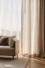 A soft oak media unit, simple, neutral sofa and linen curtains gently move in the summer breeze.