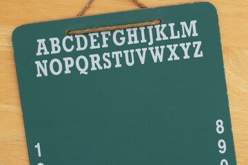 Green chalkboard with alphabet on wood desk