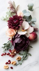 Autumn floral arrangement with pomegranate seeds and walnuts on marble