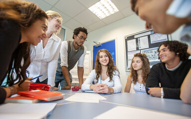 Teenage Students: Group Project. A group of college students working together with their teacher in...