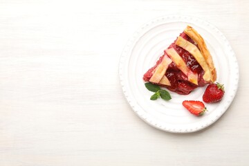 Piece of tasty strawberry pie and berries on white wooden table, top view. Space for text