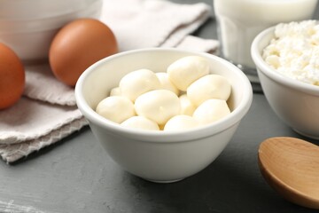 Different dairy products and eggs on grey wooden table, closeup