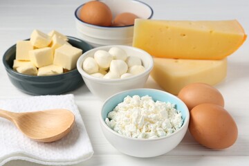 Different dairy products and eggs on white wooden table, closeup
