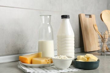 Different dairy products on gray textured table in kitchen