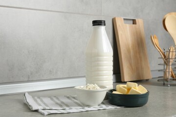 Different dairy products on gray textured table in kitchen