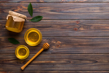 Honey jar with wooden honey dipper on white background top view with copy space. Delicious honey bottle