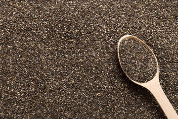 Space for text Texture of chia seeds with wooden spoon, superfood concept. Top view