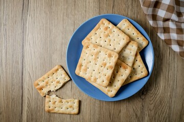 Cracker in a blue plate on wooden background table