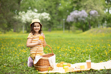 Cute little girl having picnic at summer park with family