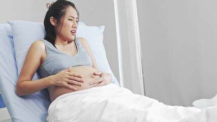 Good husband takes care and holds hands to encourage his pregnant wife who is nearing the due date of birth. The husband stays by her side without abandoning even the wife is very painful.