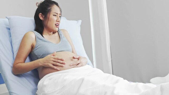 Good husband takes care and holds hands to encourage his pregnant wife who is nearing the due date of birth. The husband stays by her side without abandoning even the wife is very painful.
