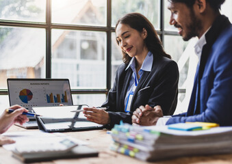 Group of Asian business people looking at digital tablet during meeting. Business people having a...