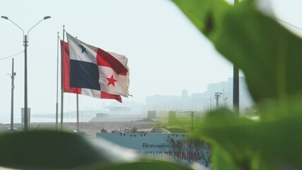 National flags of panama and peru waving in the wind on flagpoles on a sunny day