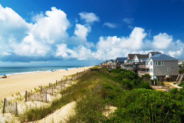 Sand dunes and Rows of beach houses on stilts on the Atlantic shore.