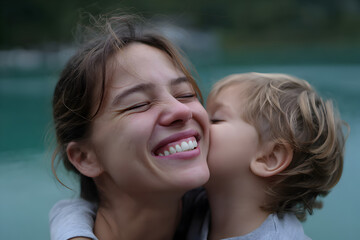 Mother and child candid outdoor hug tender kiss authentic lifestyle happy family bonding emotional parenting moment natural light stock photo