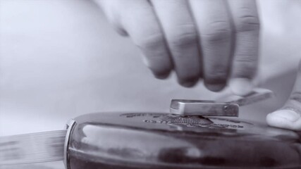 tape measure, old version since 1989. Construction tape measure, length measurement. A teenager twists and inserts a ribbon with his hand. Black and white science.