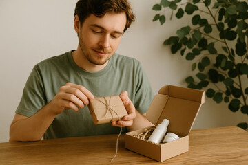 Man unpacking gift box with eco friendly cosmetics at home