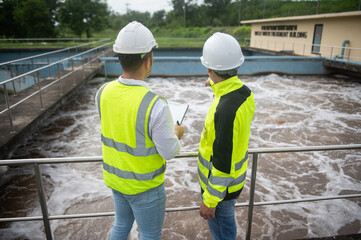Two engineers are inspecting the operation of a wastewater treatment plant