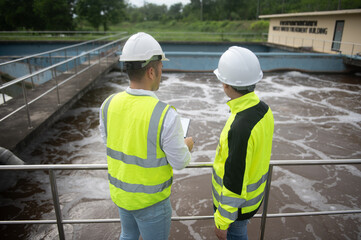Two engineers are inspecting the operation of a wastewater treatment plant