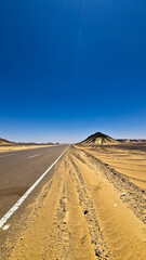 Ash-covered hills in Egypt's Black Desert under a clear sky, scenic and remote landscape. Volcanic	