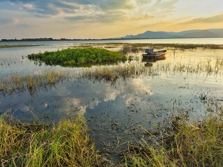 Fisherman boat at manmade lake known as Timah Tasoh during a sunset