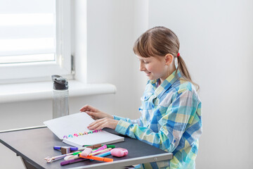 Smiling girl reading notes in colorful notebook