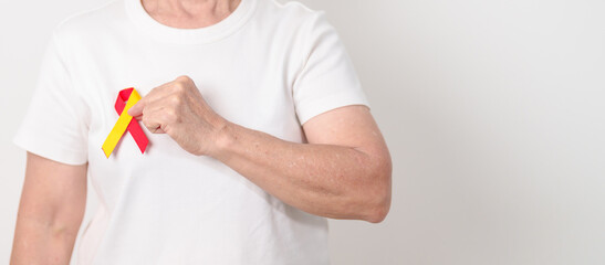 World hepatitis day awareness month, 28 July. elderly woman with Red and Yellow ribbon. Liver...