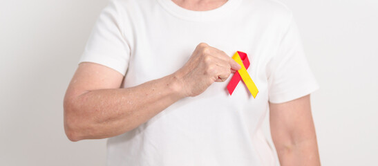 World hepatitis day awareness month, 28 July. elderly woman with Red and Yellow ribbon. Liver...