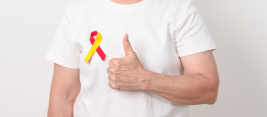 World hepatitis day awareness month, 28 July. elderly woman with Red and Yellow ribbon. Liver...
