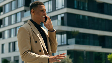 Happy African American ethnic business man walking in city going walk go urban outdoors office...