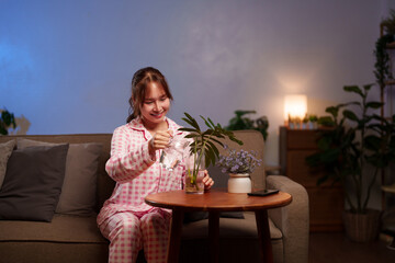 Asian Woman Waters Indoor Plant for Longevity Lifestyle Home Gardening Houseplant Care Enjoying...