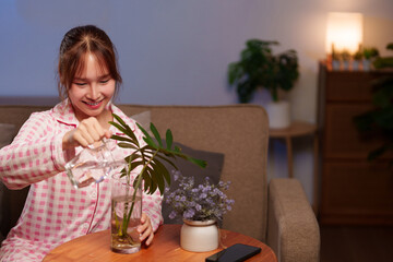 Asian Young Woman Adds Water to Vase for Longevity Lifestyle Indoor Gardening Plant Care...