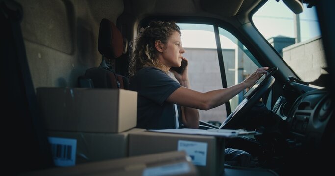 Female Product Supplier in Truck with Cardboard Boxes Using Tablet Computer, Talking by Phone. Female Driver Working in Express Delivery Service, Delivering Online Orders, E-Commerce Goods, Food.
