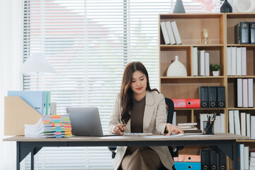 Focused Professional at Work: A poised woman is deeply engrossed in her tasks. Natural light floods...