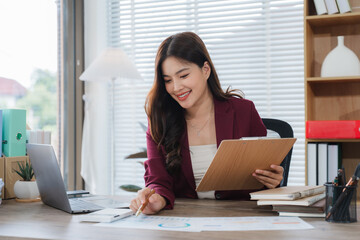 Professional Woman at Work: A focused and radiant professional woman, diligently reviewing...
