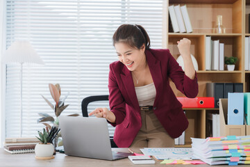 Celebrating Success at the Desk: An image of an elegant young professional celebrating with an...