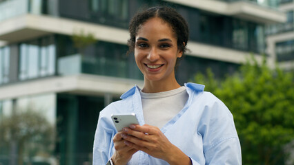 Satisfied African American woman female girl worker businesswoman business lady user holding mobile...