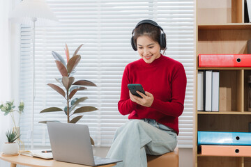 Contented Study Session: A student smiles while studying, immersed in her books and technology,...