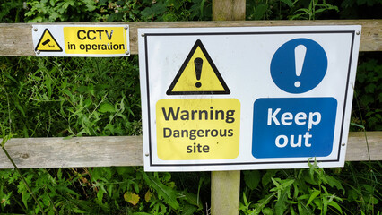 warning signs on a wooden fence