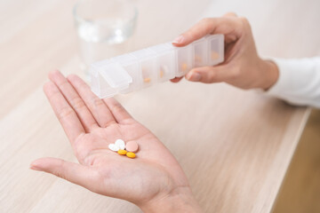Sick asian young woman, girl holding tablet pill on hand pour capsule from medication box,...