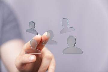 Hand interacts with digital icons representing a team.  Ideal for collaboration, networking, and...
