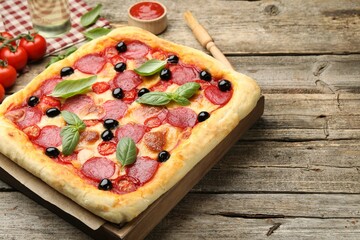 Tasty homemade pizza and ingredients on wooden table, closeup
