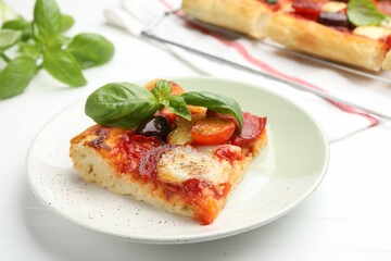 Piece of tasty homemade pizza on white wooden table, closeup